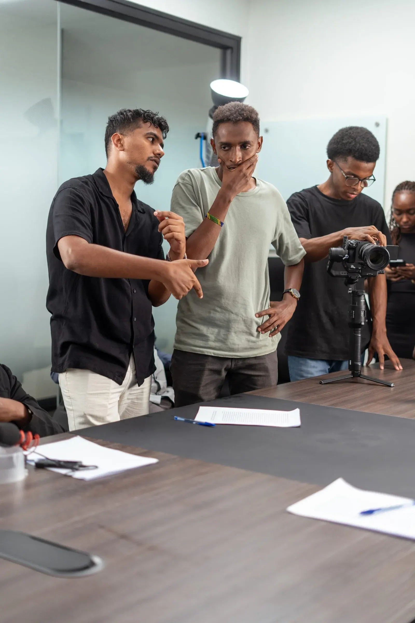Three crew members review a shot beside a camera on a stabiliser during an Umoja shoot